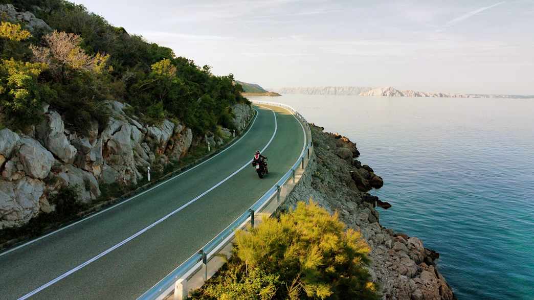 Motorrad auf der Küstenstraße in Kroatien mit Blick aufs Meer.