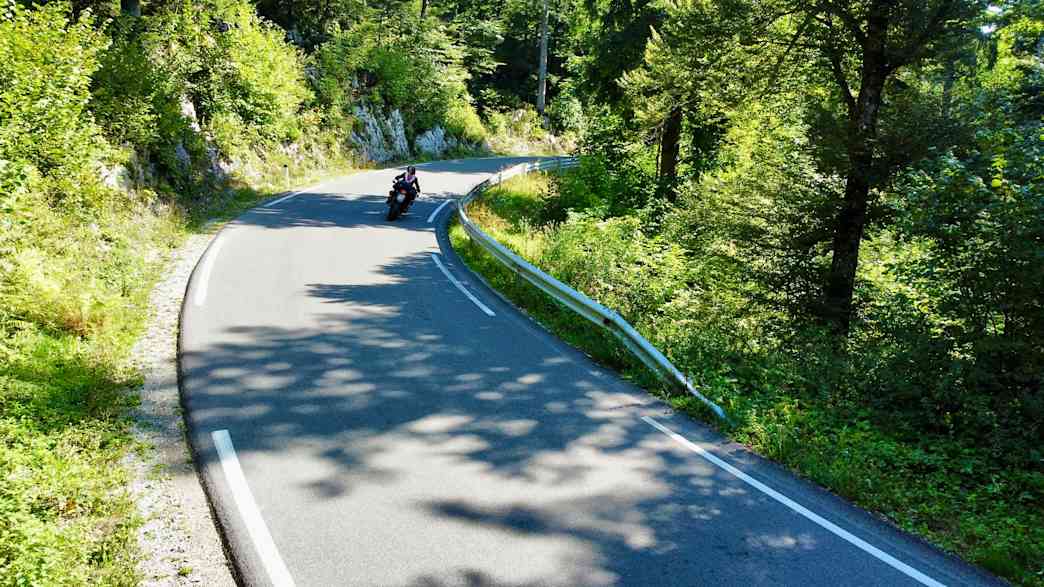 Motorradfahrer auf kurviger Landstraße bei Postojna in Slowenien.