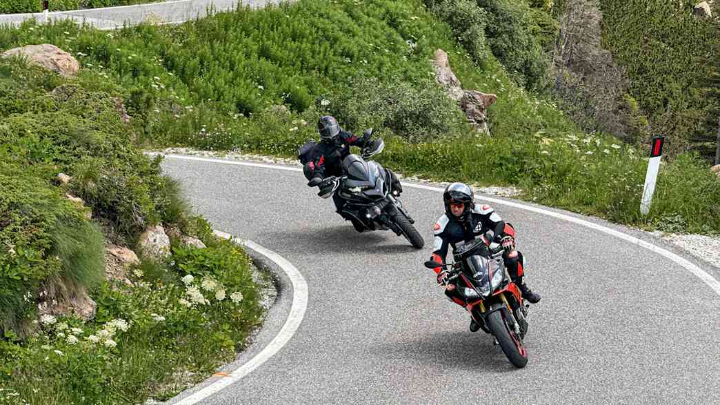 Zwei Motorradfahrer fahren auf einer Straße am Manghenpass