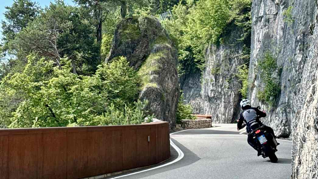 Ein Motorradfahrer fährt auf einer Straße am Mendelpass
