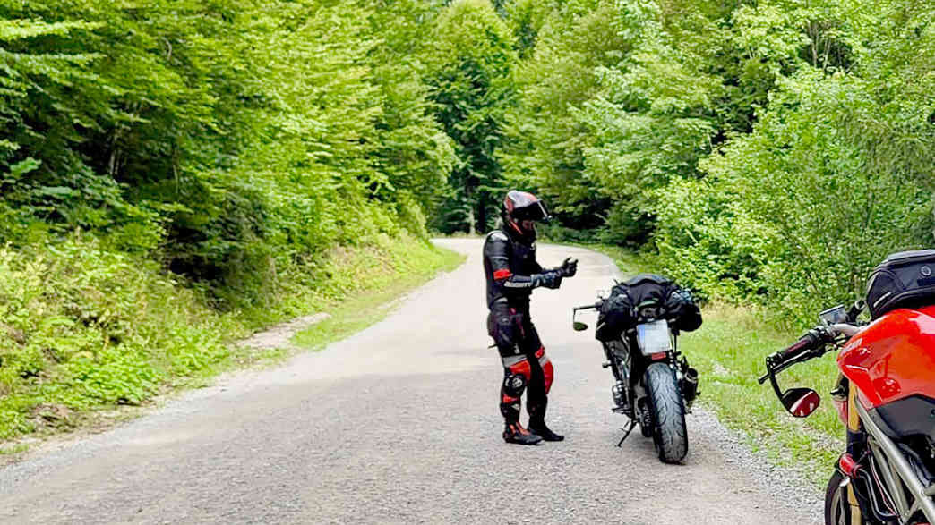Motorradfahrer machen eine Pause auf einer Landstraße in Predjama
