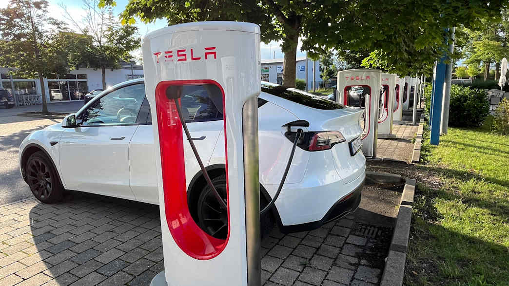 Ein Tesla Model Y steht an einem Tesla Supercharger