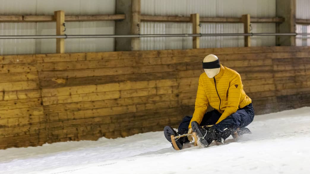 Ein Dummy fährt auf einem Schlitten beim ADAC Schlittencrashtest in der Skihalle in Bottrop