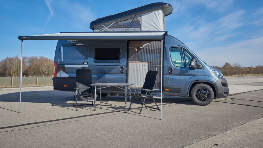 Seitenansicht des Hannes Camper mit aufgebautem Campingset und Dachzelt