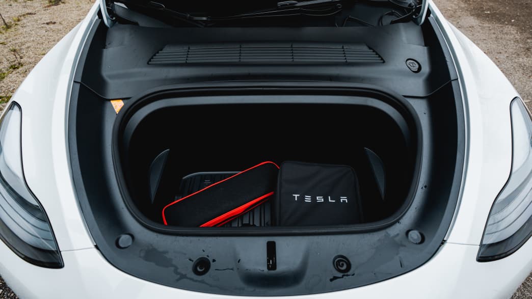 Die geöffnete Motorhaube mit Fach für das Ladekabel im weissem Elektro-SUV Tesla Model Y