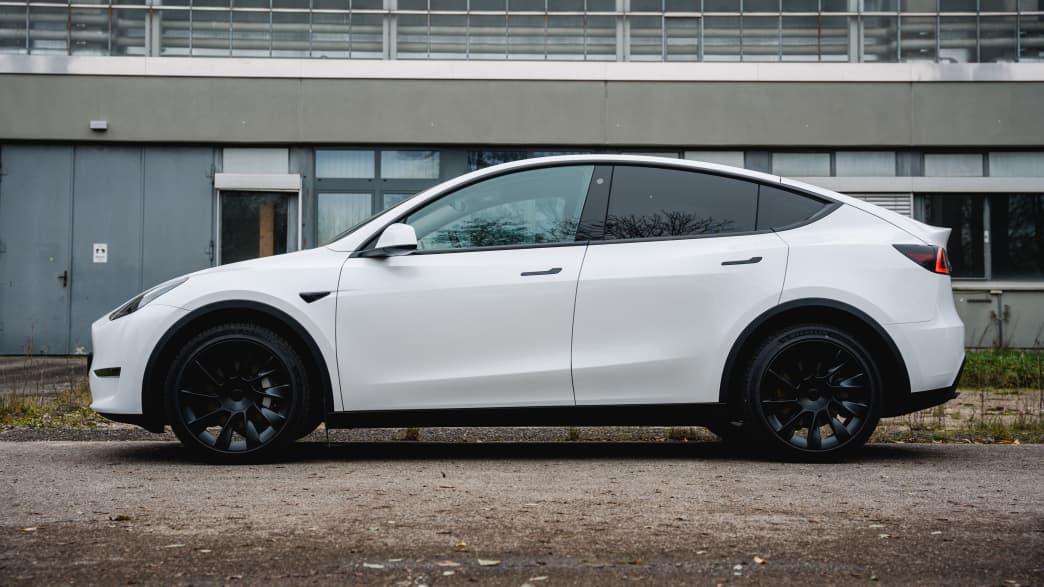 Ein weisses Elektro-SUV Tesla Model Y von der Seite fotografiert