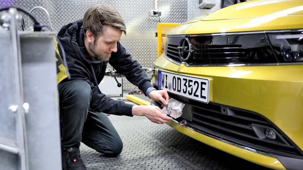 Ein Mitarbeiter klebt Sensoren am beim Eco Test 2023 im ADAC Technik Zentrum Landsberg.