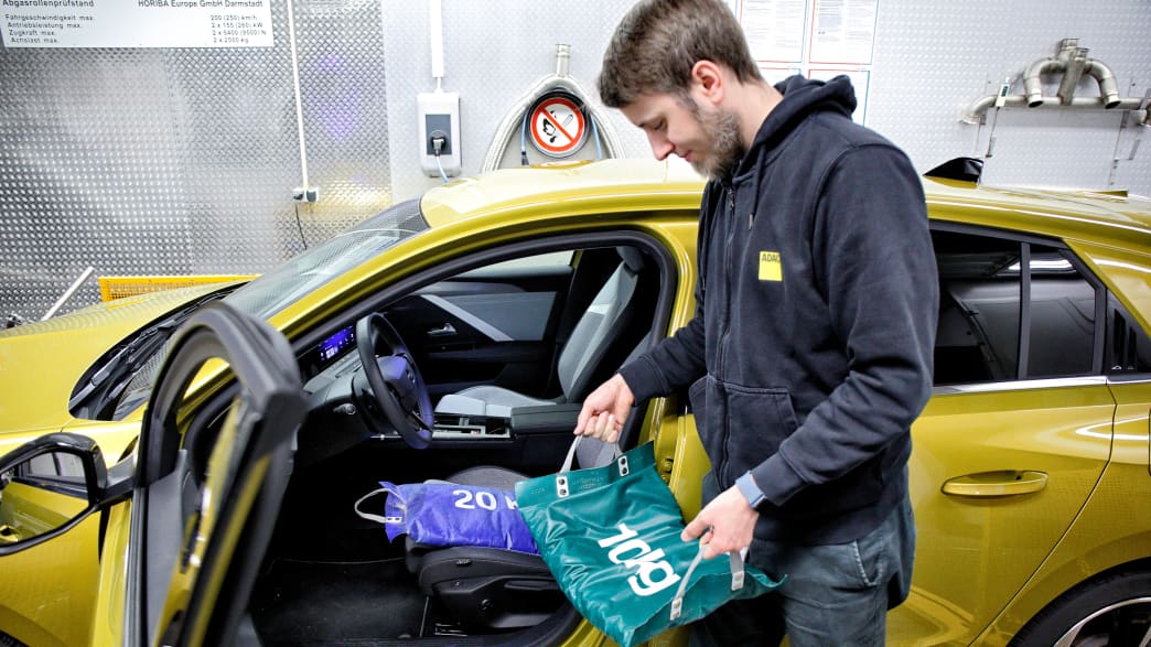 Gewichte werden auf den Fahrersitz gelegt beim Eco Test 2023 im ADAC Technik Zentrum Landsberg