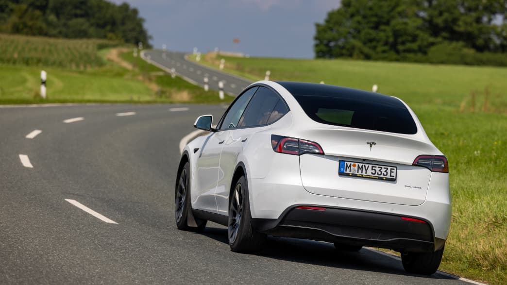 Der Tesla Y fahrend von hinten auf einer Landstraße zu sehen