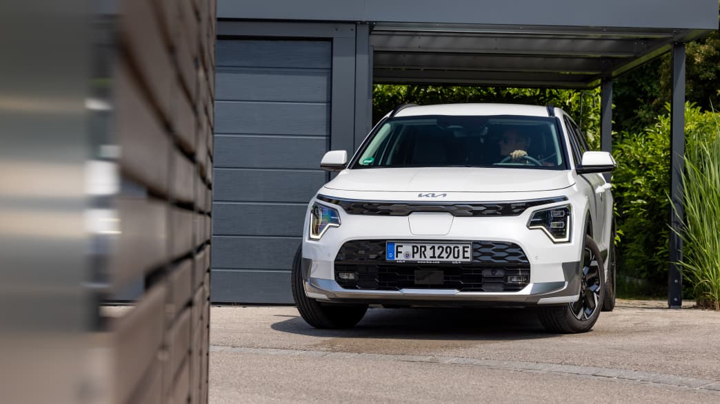 Der Kia Niro EV fährt aus einer Hausgarage