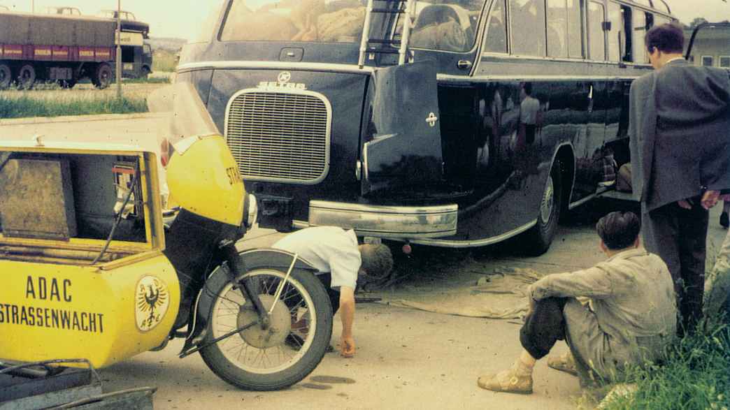 Ein ADAC Straßenwachtfahrer leistet Pannenhilfe im Jahre 1959