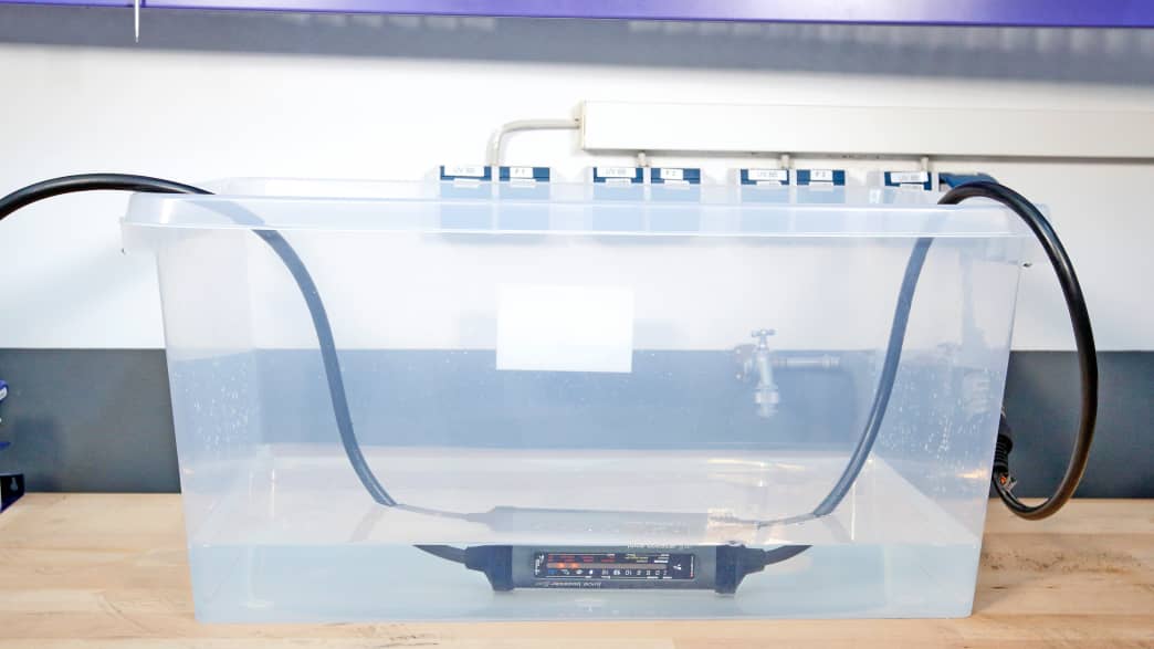 Eine moile Wallbox liegt in einem Plastikbehälter mit Wasser