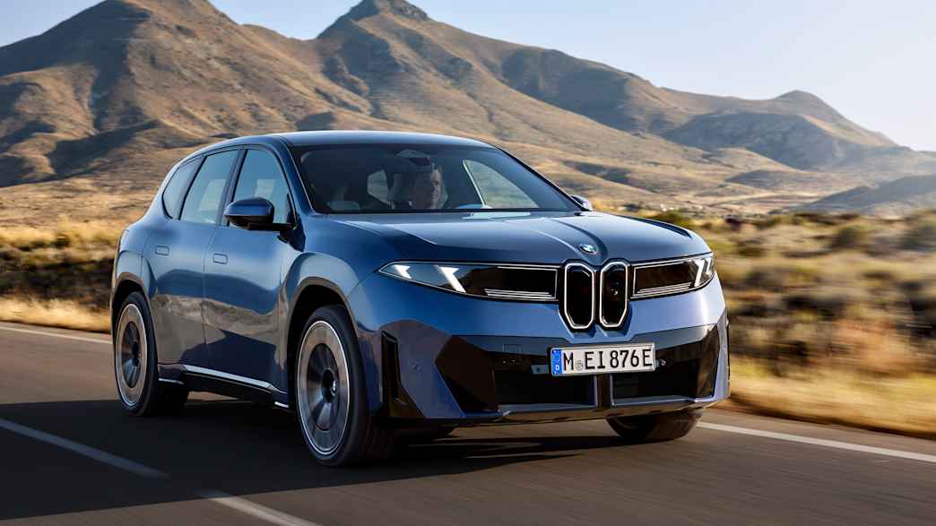 Der BMW iX3 f&auml;hrt auf einer Stra&szlig;e, fotografiert von vorne.