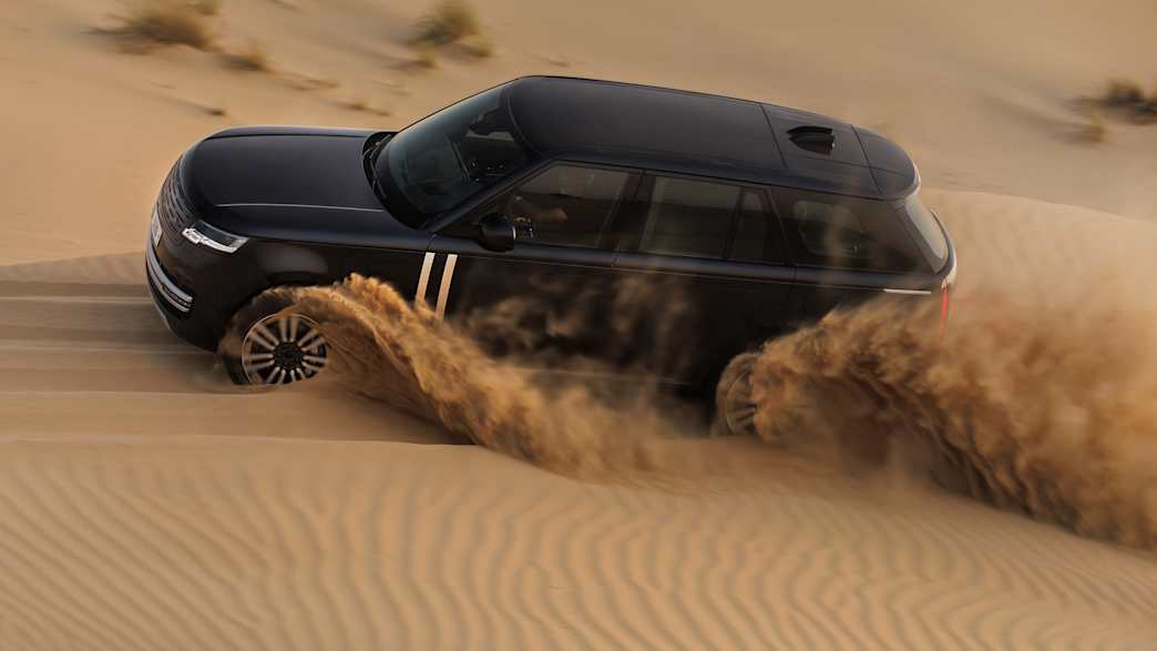 Ein Range Rover Electric fährt durch Sand