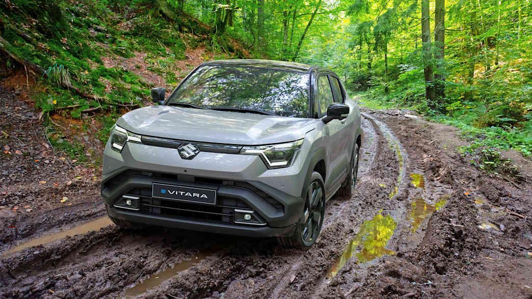 Frontansicht eines Suzuki e-Vitara der auf einem matschigen Waldweg fährt