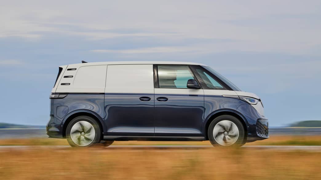 Ein blau-weißer VW ID. BUZZ fahrend auf einer Straße