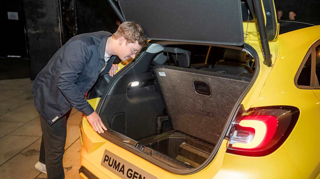 Der ADAC Redakteur Andreas Huber steht vor dem geöffneten Kofferraum des neuen Ford Puma