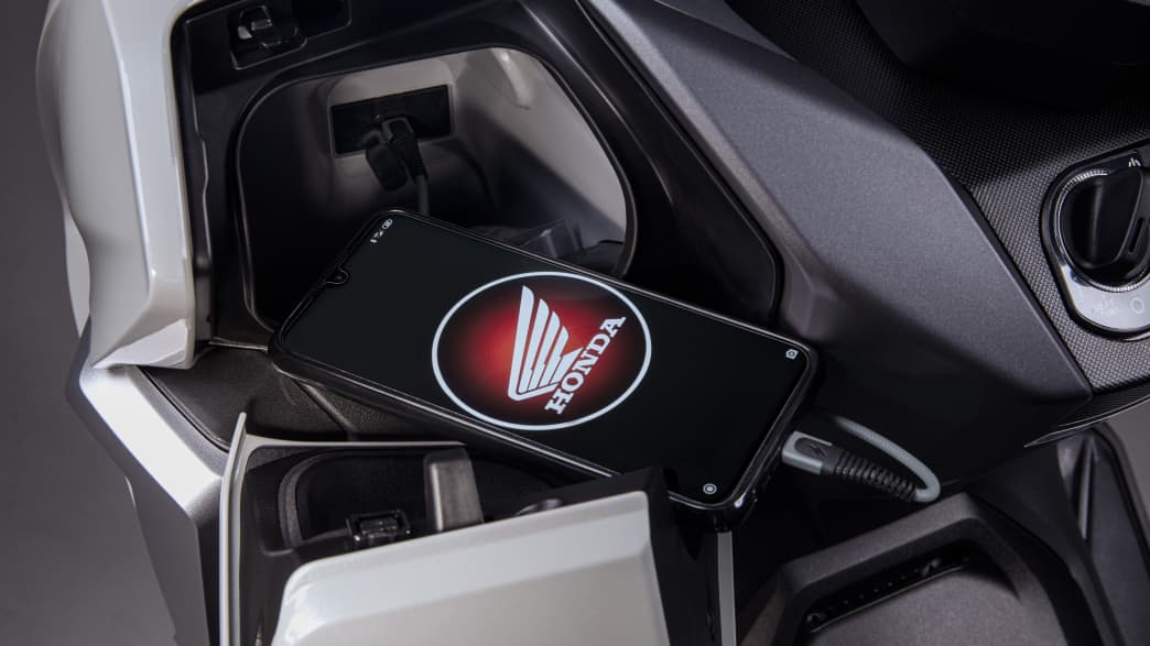 Handy am Ladekabel der Honda Forza 350