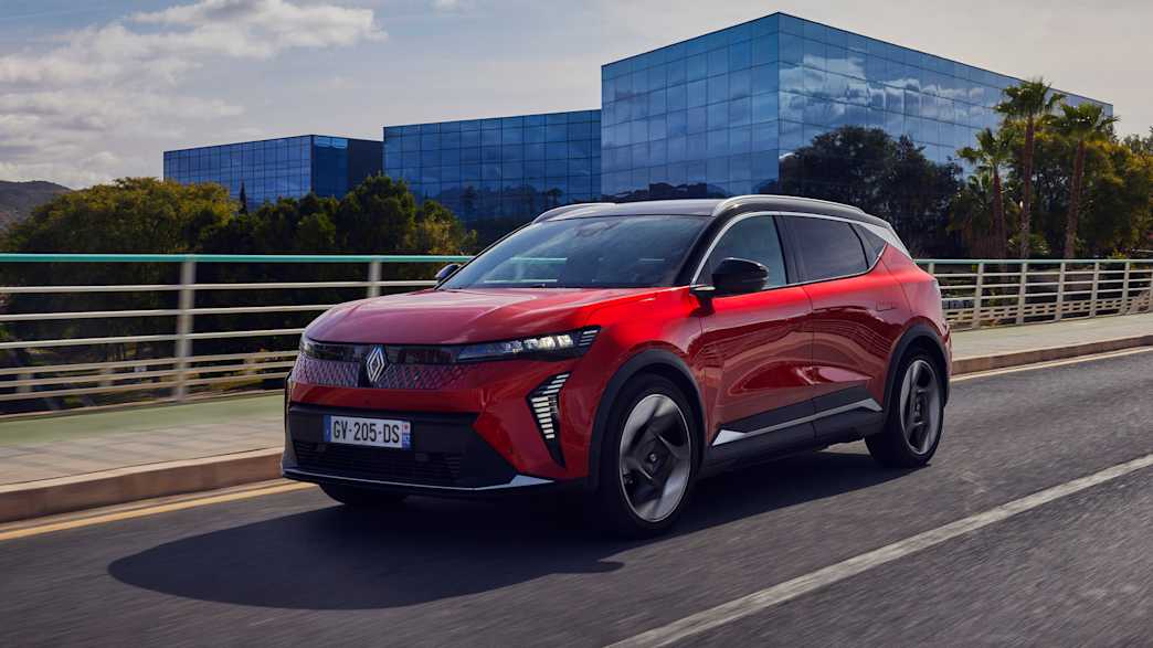 Front und Seitenansicht eines roten Renault Scenic E-Tech Electric der auf einer Straße fährt