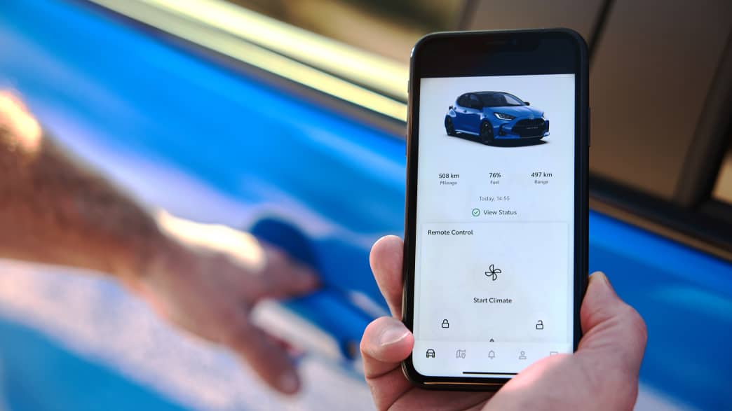 Jemand startet die Klimaanlage des Toyota Yaris per Handy