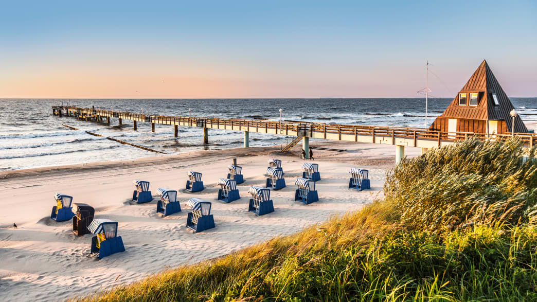 Strandkörbe am Strand der Insel Usedom mit einem langen Steeg
