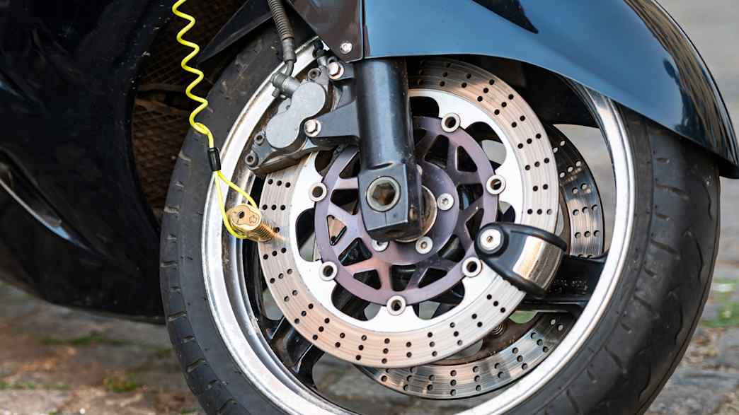 Ein Motorrad ist gegen Diebstahl mit einem Scheibenbremsenschloß gesichert