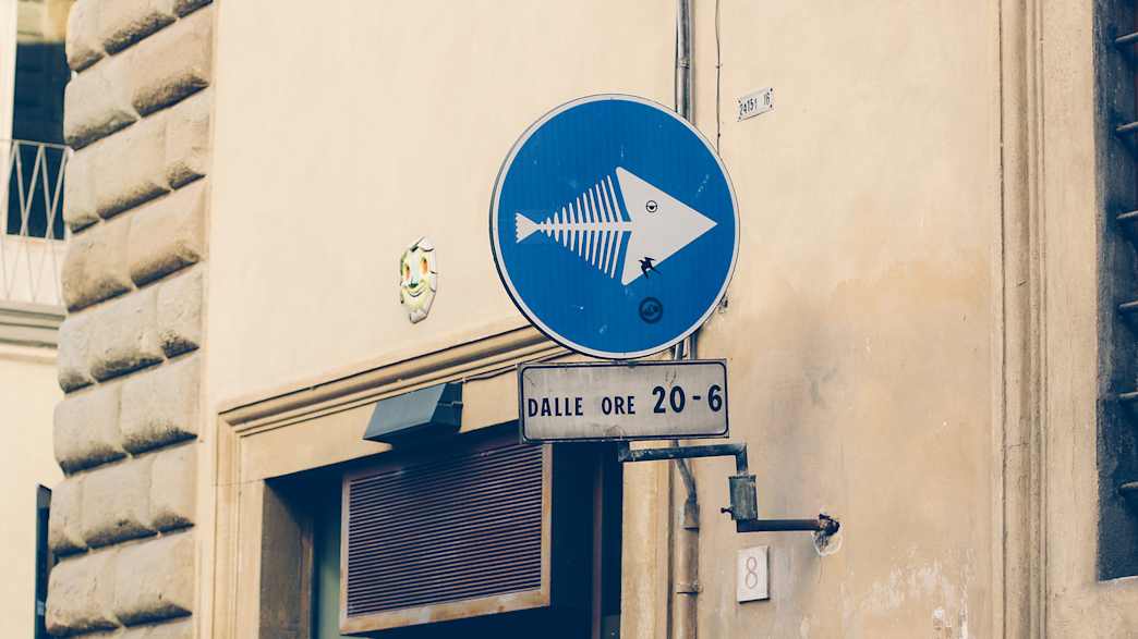 Street Art auf einem Straßenschild in Florenz