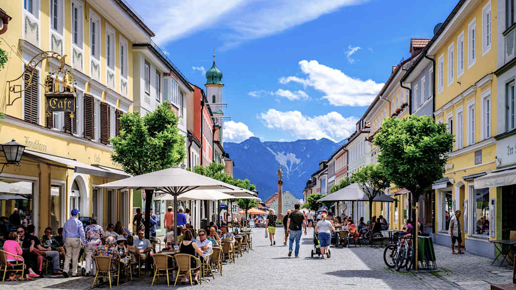 Menschen sitzen in einem Cafe in der historischen Altstadt von Murnau