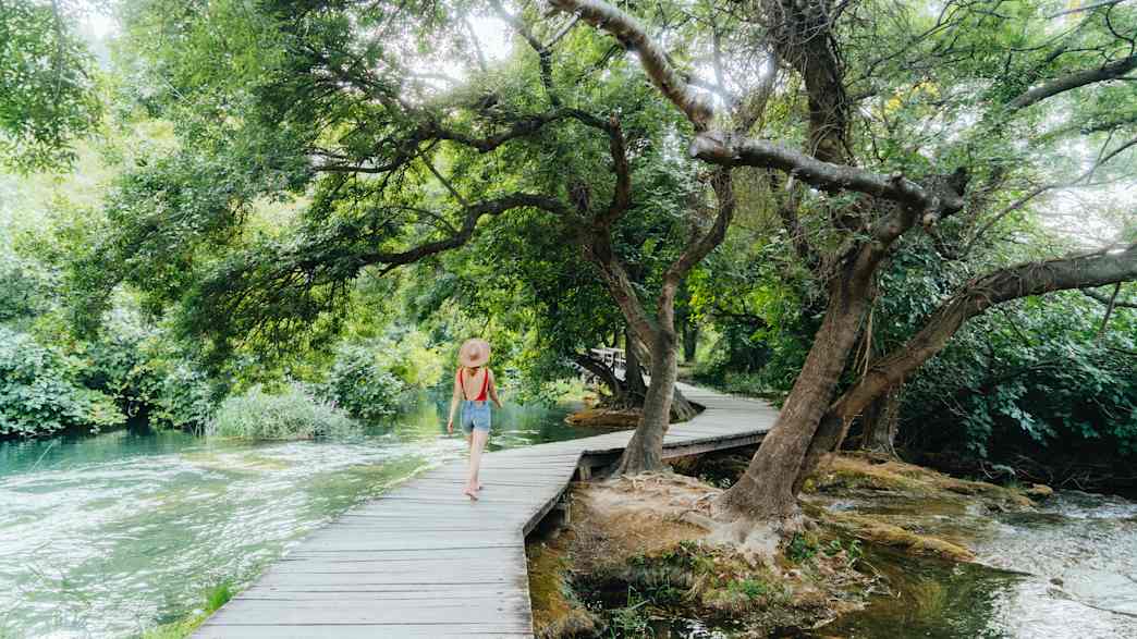 Eine junge Frau läuft durch den Krka National Park