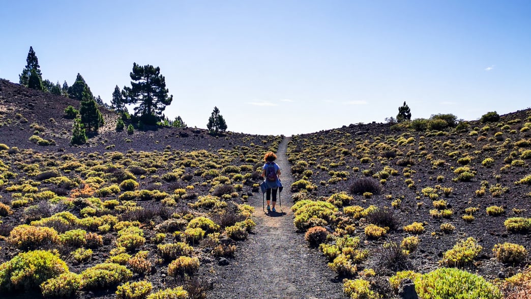 Eine Frau wandert auf der "Ruta de los Volcanes" auf der Insel La Palma