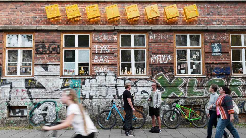 Eine Radfahrerin und ein paar Fußgänger im Stadtteil Plagwitz in Leipzig