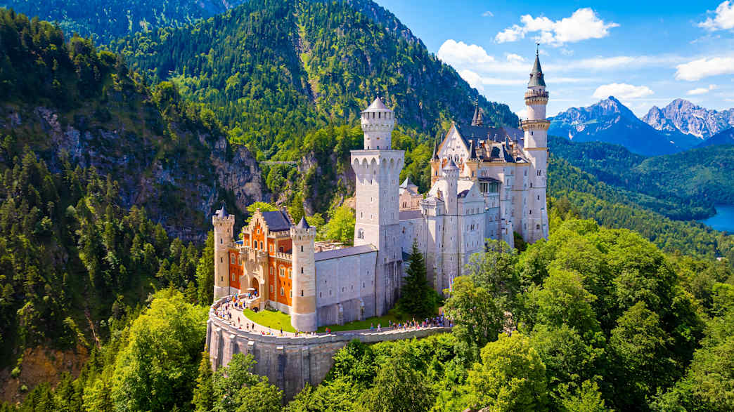 Blick auf Schloss Neuschwanstein, im Hintergrund Berge