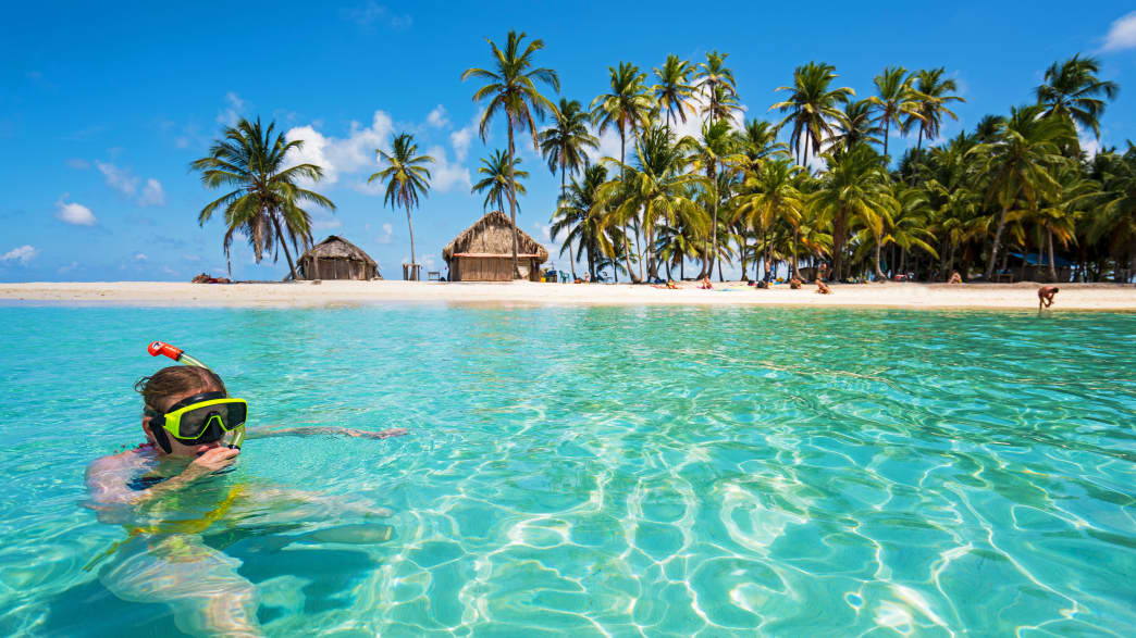Frau beim Schnorcheln im türkisblauen Wasser auf der Isla de Perro im San Blas Archipel  in Panama