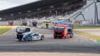 Truck-Rennen mit mehreren Trucks, die auf einer Rennstrecke konkurrieren, beobachtet von einer begeisterten Menge auf den Tribünen.