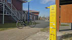 Ein Fahrrad steht auf einem asphaltierten Weg vor einem Haus. Auf der rechten Seite des Weges befindet sich eine gelbe Radservice-Säule.