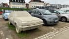 Der Fiat 500e steht neben einem verkommenen Auto auf einem Parkplatz