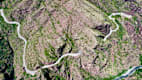 Luftaufnahme zeigt die geschwungene Straßenführung in den Gorges de Daluis, eingebettet in die felsige Landschaft der französischen Seealpen.