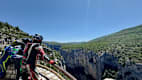 Motorradfahrer steht an einem Aussichtspunkt mit Blick auf die beeindruckende Schluchtlandschaft der Gorges du Verdon.