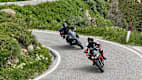 Zwei Motorradfahrer fahren auf einer Straße am Manghenpass