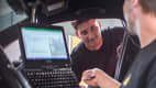 Zwei Männer mit einem Computer, testen ein Auto