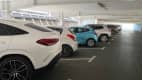 Ein blauer Renault Clio im Parkhaus zwischen lauter weißen Autos