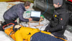 Zwei Techniker lesen die Daten eines Dummy nach dem ADAC Schlittencrashtest in der Skihalle in Bottrop