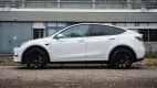 Ein weisses Elektro-SUV Tesla Model Y von der Seite fotografiert
