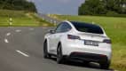 Der Tesla Y fahrend von hinten auf einer Landstraße zu sehen