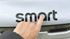 Die Hand von Redakteur Wolfgang Rudchies zeigt auf das Logo des neuen Smart #5