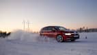 Ein Auto fährt auf einer zugeschneiten Strecke beim Winterreifentest in Finnland