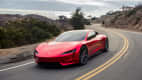 Front und Seitenansicht eines fahrenden Tesla Roadster