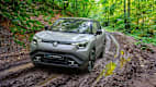 Frontansicht eines Suzuki e-Vitara der auf einem matschigen Waldweg fährt