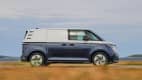 Ein blau-weißer VW ID. BUZZ fahrend auf einer Straße