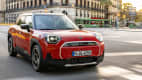 Ein roter Mini Aceman fährt durch eine Stadt